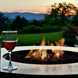port style red wine at sunset on a back yard patio outdoor living space with a fire pit table.